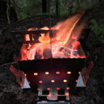 Ultra lightweight backpacking stove SIEGE Flat-Pack Stove with glowing hot fire.